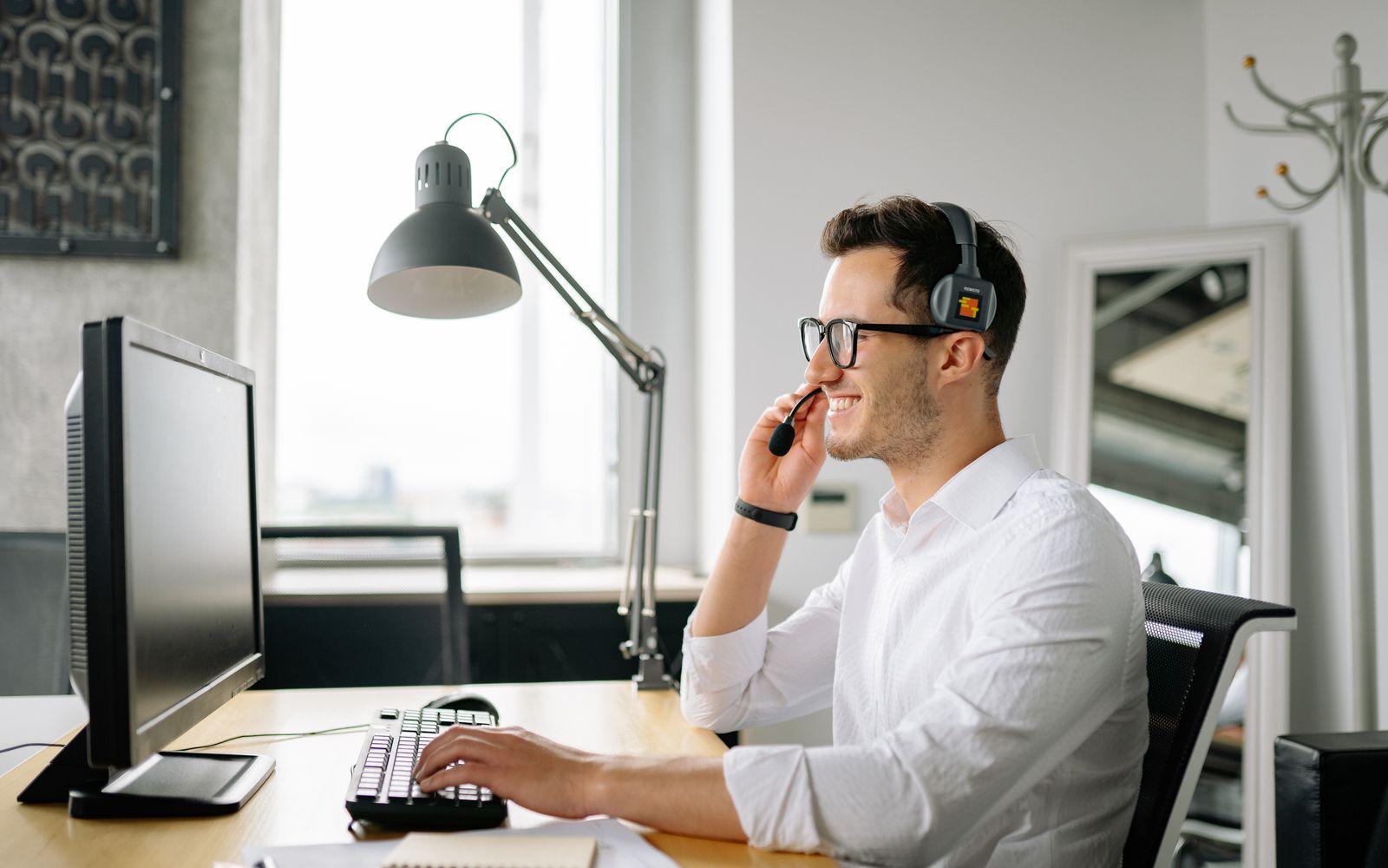 Conseiller souriant avec casque à son poste de travail